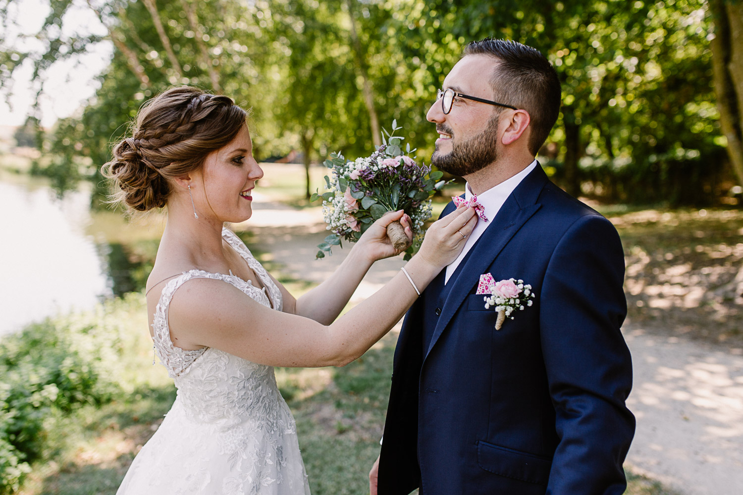 Mariée en train de rajuster la boutonnière de son époux